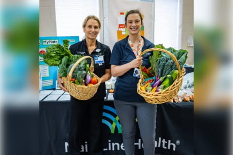 Main Line Health employees holding produce from the King of Prussia rooftop garden