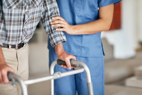 Nurse assisting patient with walker