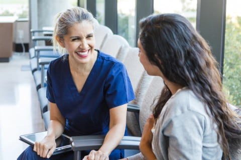 Hospital employee and patient sitting in waiting room