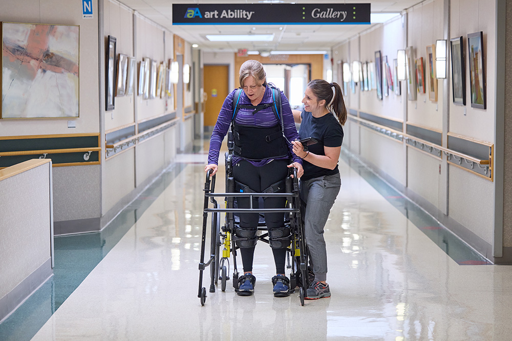 Rehabilitation therapist assists patient with walker