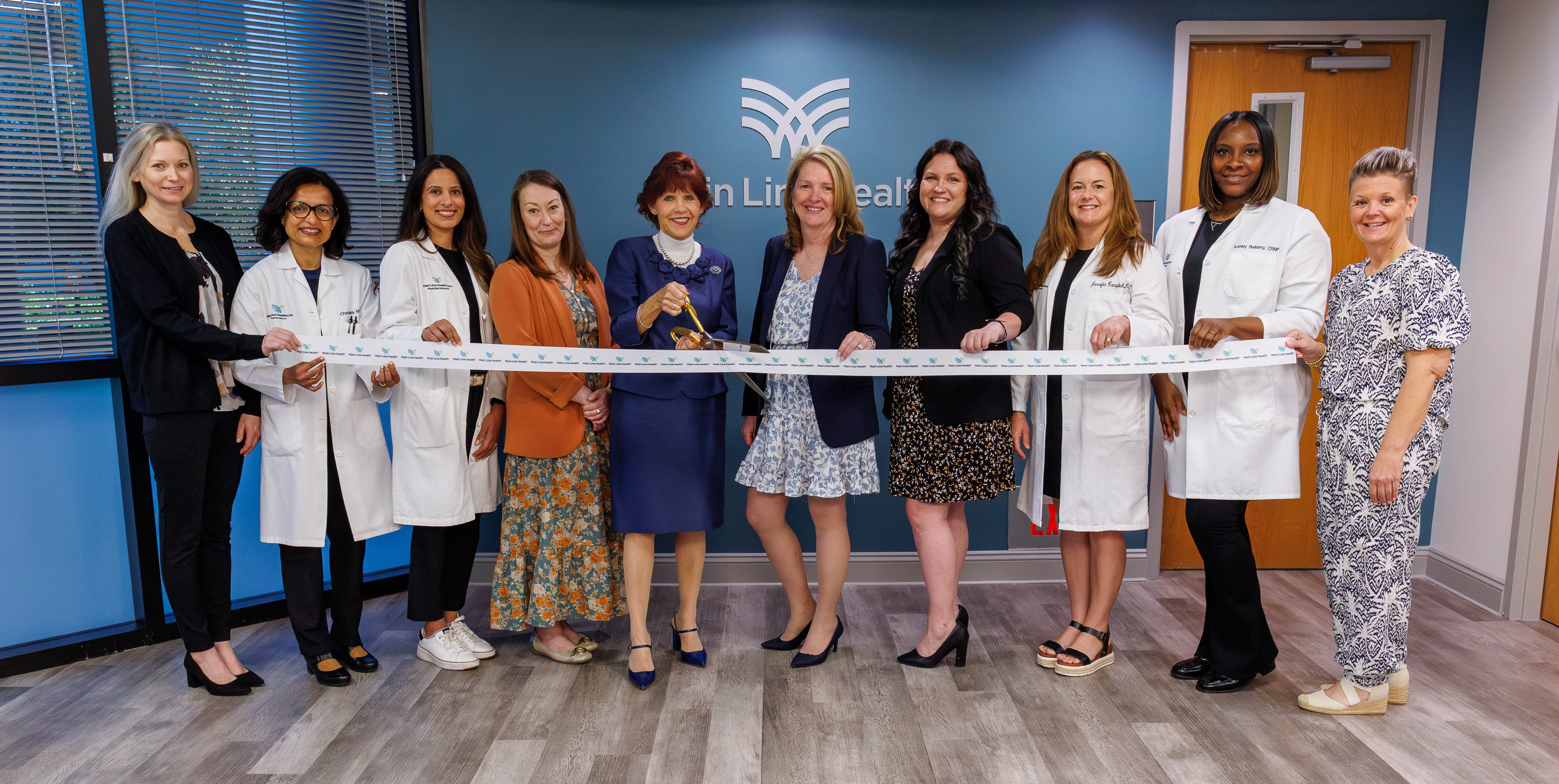 Barbara Wadsworth, center with scissors, as she officially opens Main Line Health Oaks, with other Main Line Health employees